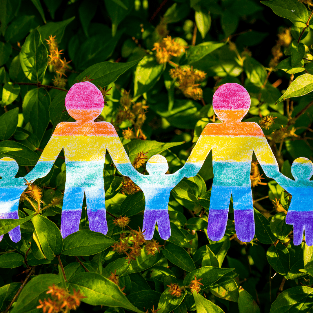 Image of paper people on rainbow colour same as the LGBT Pride Flag 