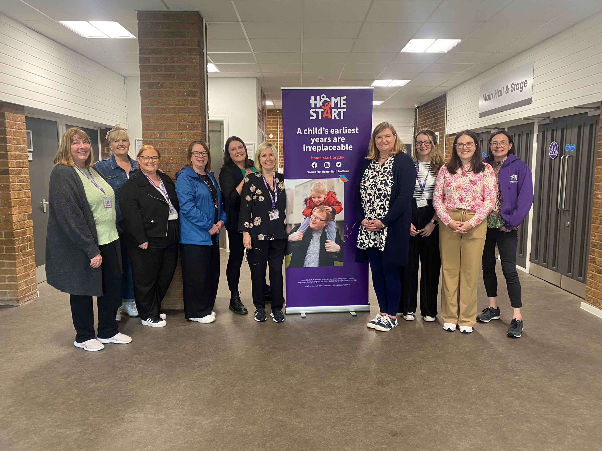 Image of the minister with Home-Start staff team in the community centre.