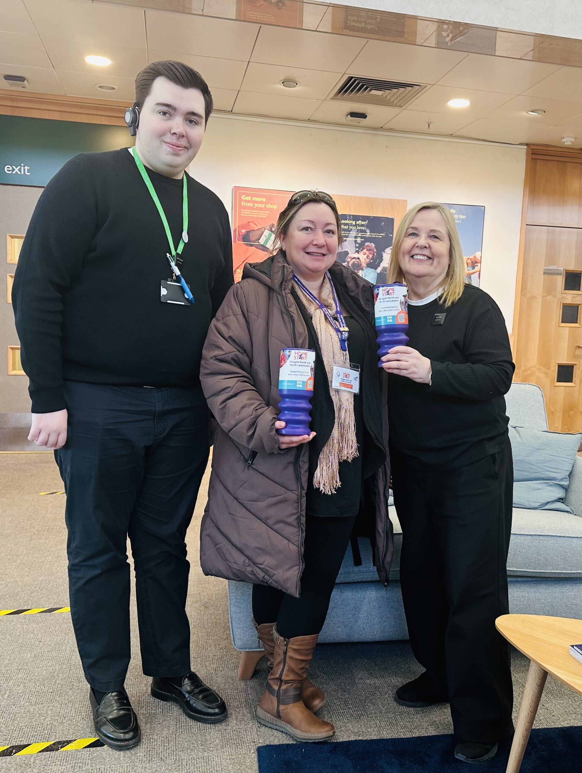 Image of Celia with 2 staff from John Lewis, holding the fundraising tins.