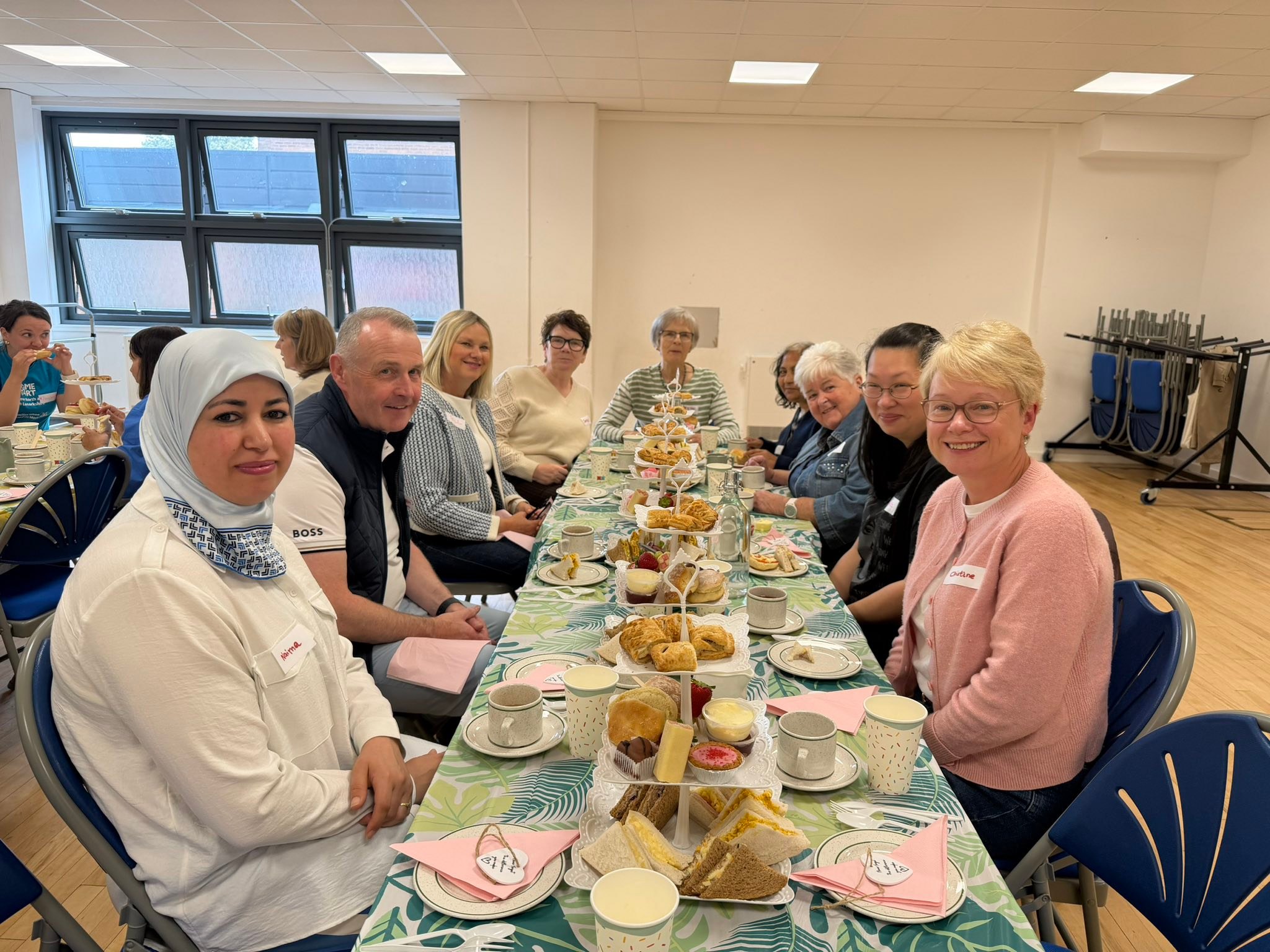 Image of Volunteers and Trustees sat at a table with an afternoon tea.