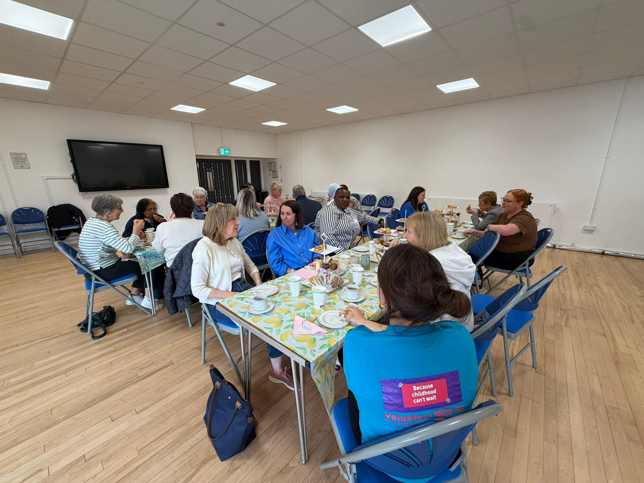 Image of volunteers at tables  eating an afternoon tea.